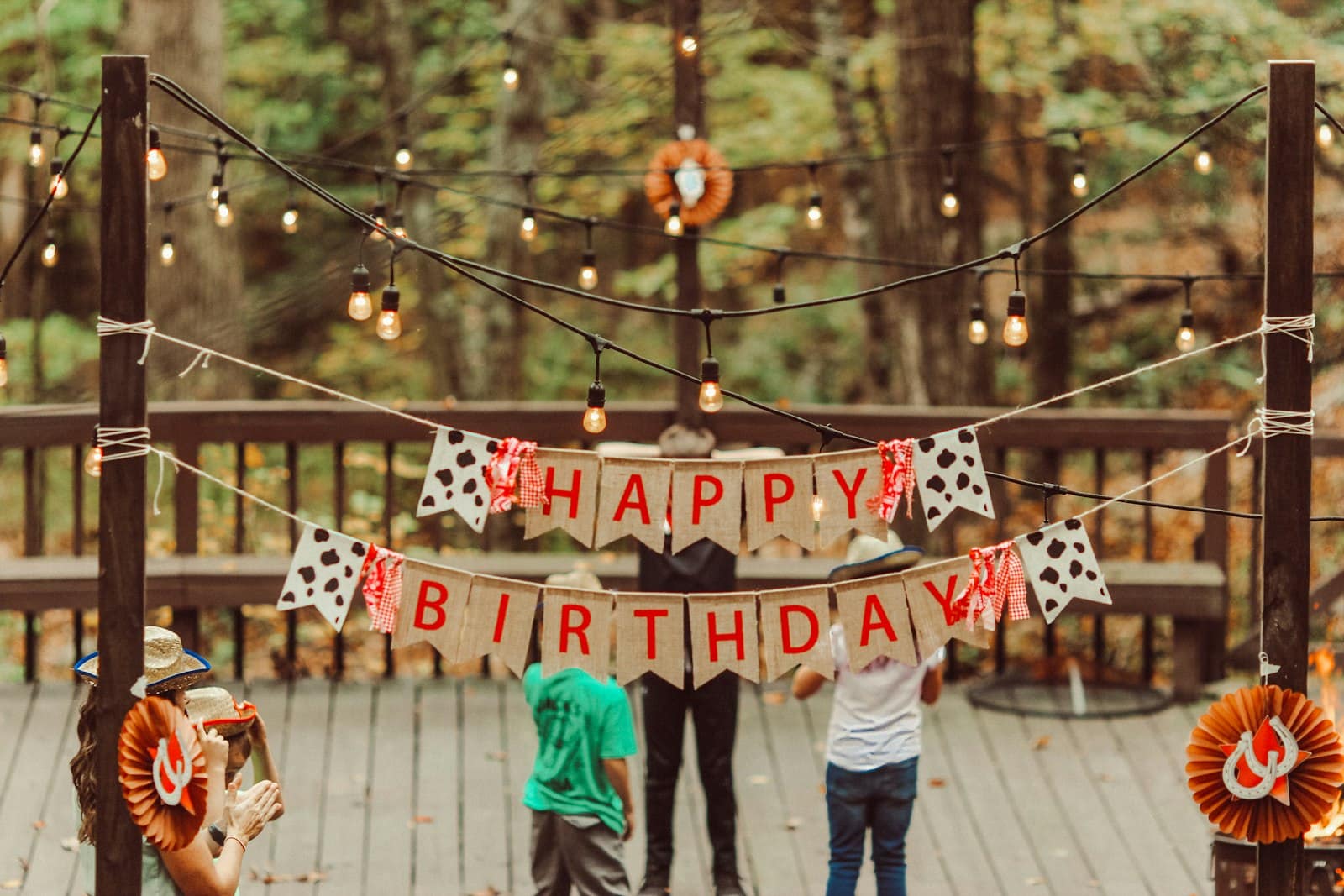 Happy birthday bunting and string lights over a back deck