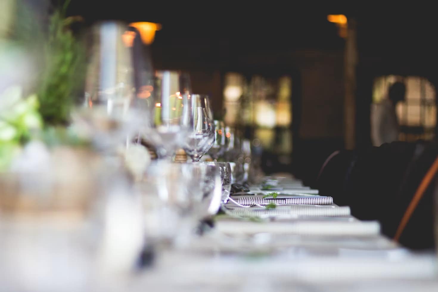 Glassware and candlelight running down a long dinner table