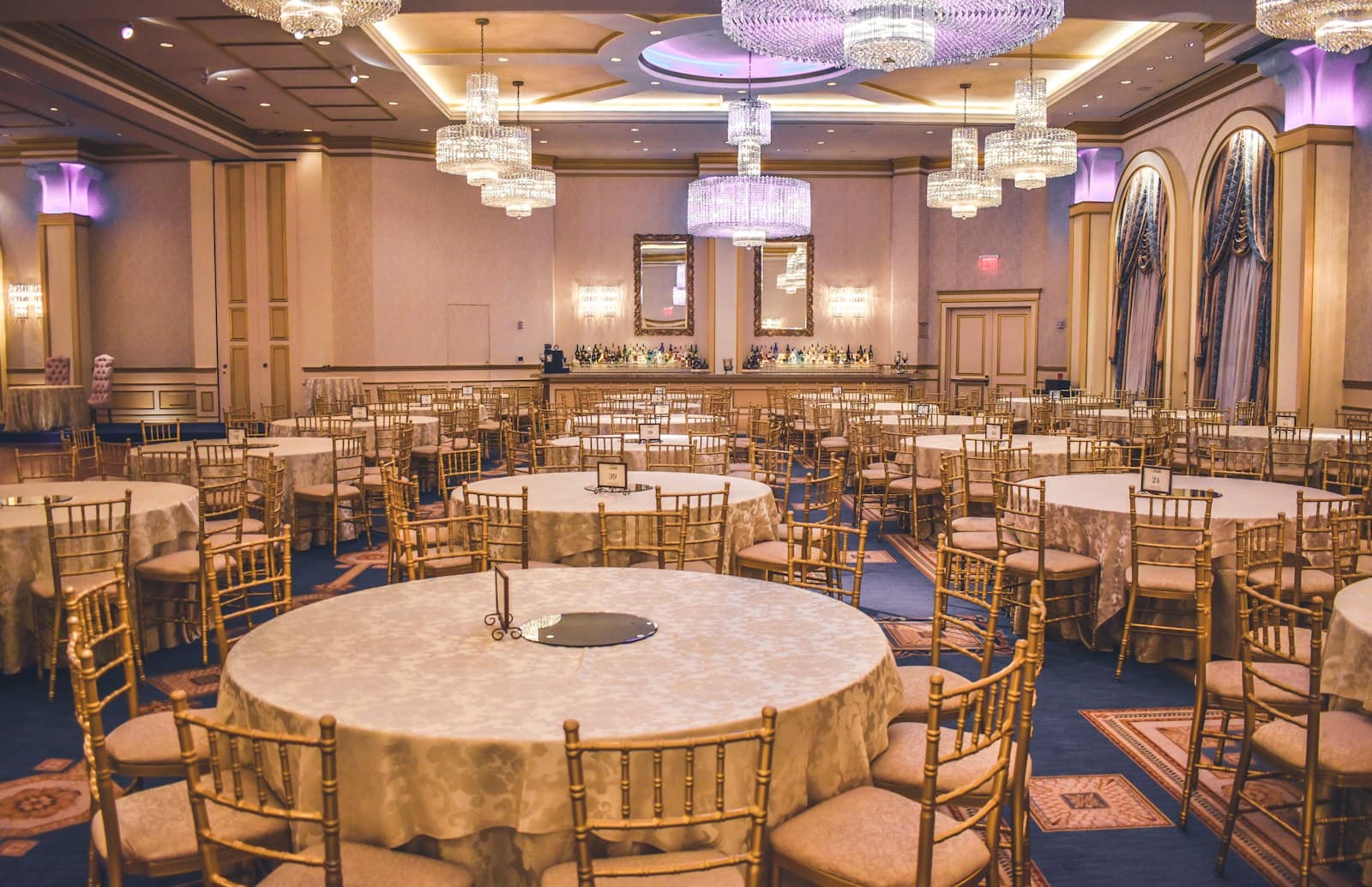 Round tables and gold chiavari chairs set for a wedding reception
